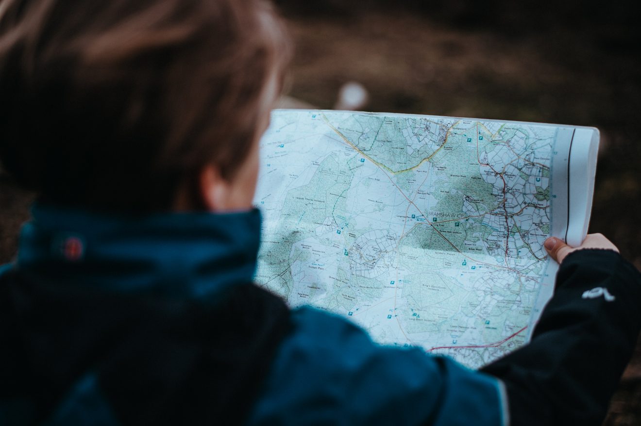 Woman holding a trail map, a critical piece of backpacking gear.