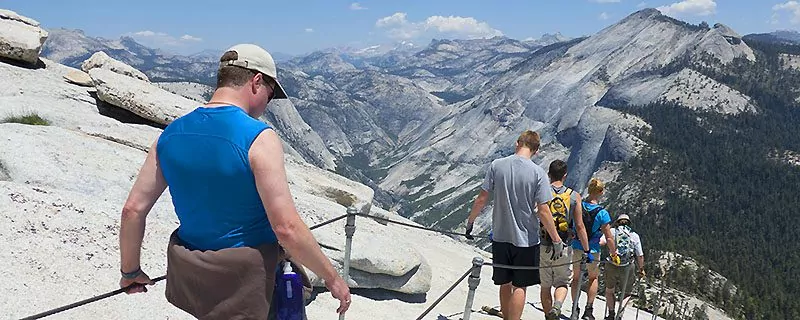 Hikers descending mountain with railing