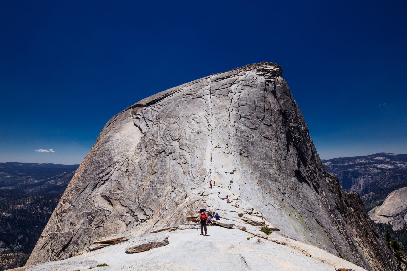 Hiker standing at the base of Half Dome in Yosemite National Park