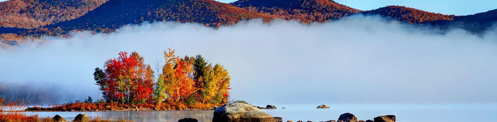 Early morning autumn in the Green Mountain National Forest in Vermont. Photo taken on a calm foggy colorful morning during the peak autumn foliage season. Vermont's beautiful fall foliage ranks with the best in New England bringing out some of the most colorful foliage in the United States