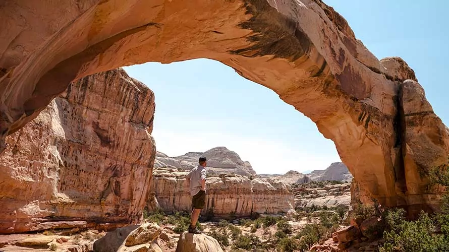 Hiker under Hickman's Bridge arch in Capitol Reef National Park