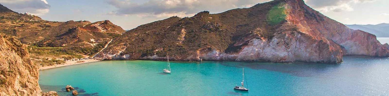 Crystal clear water in calm bay of Milos island is very attractive for sailboats and yachts